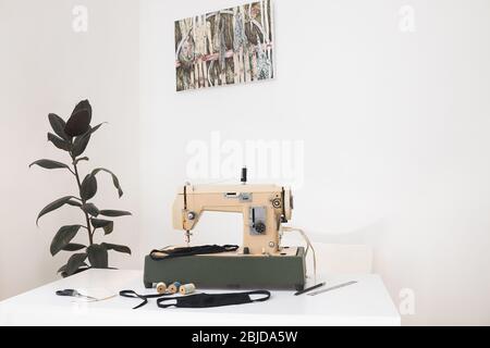 Ambiente di lavoro di Seamis a casa con macchina da cucire vintage, spazio libero per il testo Foto Stock