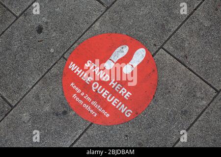 Peckham, Regno Unito. 29 aprile 2020. Vita a Londra del Sud durante il blocco di Coronavirus. Segnali di distanza sociale su un marciapiede fuori da una banca di strada alta a Peckham. ( Credit: Sam Mellish/Alamy Live News ) Foto Stock