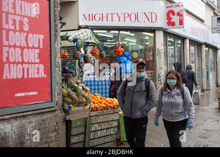 Peckham, Regno Unito. 29 aprile 2020. Le persone che indossano maschere facciali protettive si accavolano alla loro vita quotidiana nel sud di Londra durante il blocco di Coronavirus. ( Credit: Sam Mellish/Alamy Live News ) Foto Stock