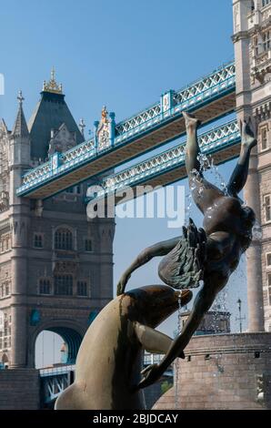 Scultura di una "ragazza con un delfino" di David Wynne sulla riva nord del Tamigi e di fronte all'iconico Tower Bridge, Londra, Regno Unito Foto Stock