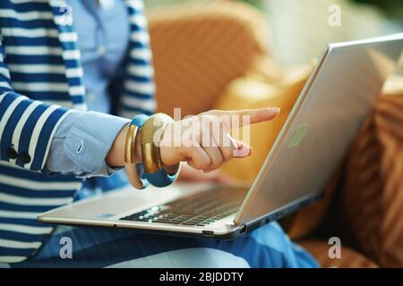 Primo piano su donne a casa nelle giornate di sole premendo il touch screen su un notebook. Foto Stock