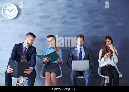 Gruppo di giovani in attesa di intervista in interni Foto Stock