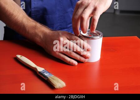 Mani di decoratore che apre può con vernice, closeup Foto Stock