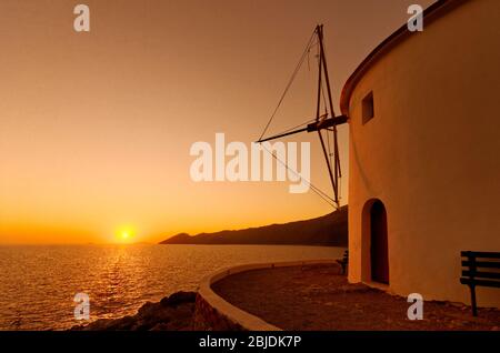 Il mulino a vento all'ingresso della baia di Panormitis nel sud-ovest di Symi, Dodecanesi, Grecia. Foto Stock