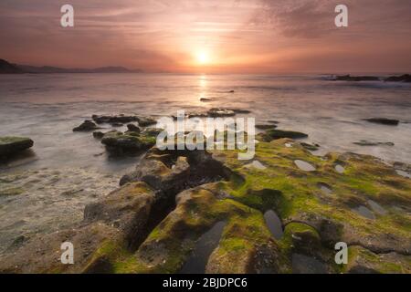 Getxo, Bizkaia/Paesi Baschi; 16 maggio 2012. Tramonto colorato sulla spiaggia di Azkorri con bassa marea Foto Stock