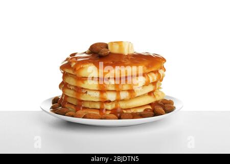 Gustosi pancake con mandorle e sciroppo di caramello isolato su bianco Foto Stock