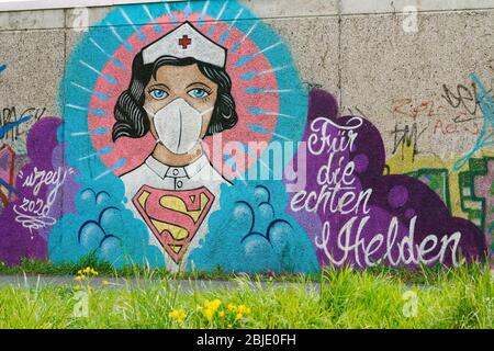 Hamm/Germania, 29 aprile 2020: Graffiti coronavirus dell'artista di strada Kai „Uzey Wohlgemuth che mostra 'Super-Nurse' con una maschera di protezione su un muro di Hamm, Germania. La Scrittura dice: 'Per i veri eroi' --- Hamm, 29.4.2020 - Corona-Kunst. Das Graffiti „Super-Nurse un einer Wand a Hamm. Eine Krankenschwester mit Mundschutz und Supermann-Logo hat der Graffiti-Künstler Kai „Uzey Wohlgemuth aus Hamm den echten Helden in der Corona-Krise gewidmet. Foto Stock