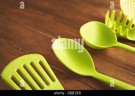 Set di utensili da cucina diversi su tavolo in legno Foto Stock