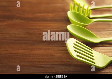 Set di utensili da cucina diversi su tavolo in legno Foto Stock