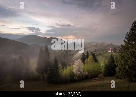 Paesaggio primaverile tramonto a Bran, Brasov, Transilvania, Romania vista naturale Springtime sul massiccio dei monti Piatra Craiului Foto Stock