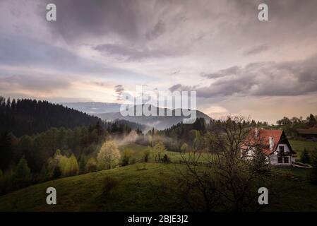 Paesaggio primaverile tramonto a Bran, Brasov, Transilvania, Romania vista naturale Springtime sul massiccio dei monti Piatra Craiului Foto Stock