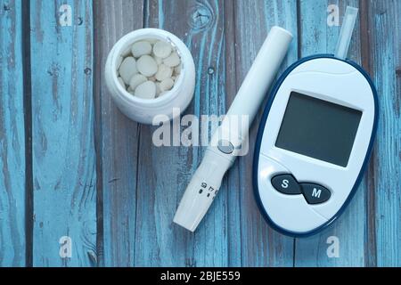 kit di misurazione dello zucchero nel sangue per il diabete su sfondo di legno Foto Stock