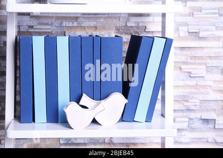 Accogliente arredamento interno: Pila di libri, mela verde, cuscini  decorativi, scatola blu con plaid e vaso con fiore bianco su un tavolo di  vetro. Distanza Foto stock - Alamy