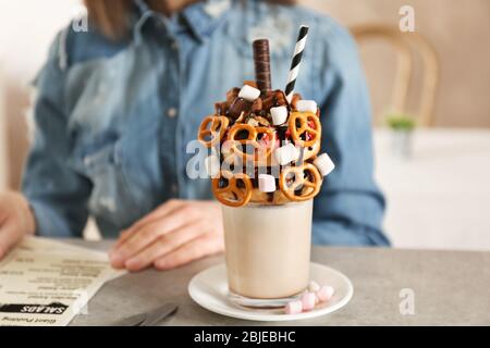 Milkshake, ciambelle e altri dolci in vetro sul tavolo Foto Stock