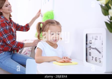 Bambina e sua madre che fanno pulizia a casa Foto Stock