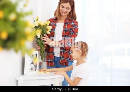 Bambina e sua madre che fanno pulizia a casa Foto Stock