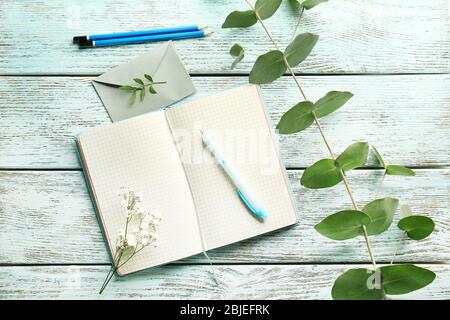 Diario aperto e fiori su tavolo di legno Foto Stock