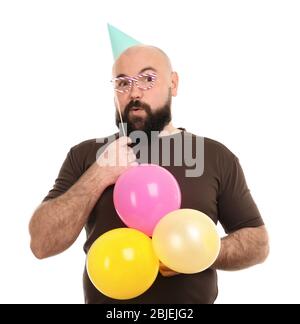 Divertente uomo grasso con cappello da festa e palloncini colorati su sfondo bianco Foto Stock