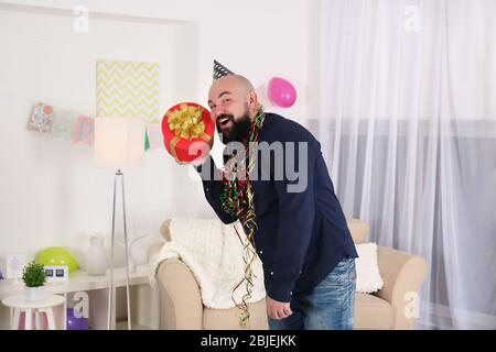 Divertente grasso uomo che celebra il compleanno a casa Foto Stock