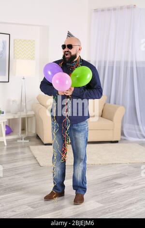 Divertente grasso uomo che celebra il compleanno a casa Foto Stock