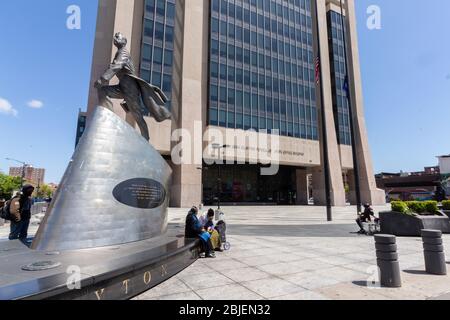 Ad Harlem, la gente si riunisce intorno ad una statua di Adam Clayton Powell nella plaza dell'edificio dell'ufficio governativo dello Stato di New York che porta il suo nome Foto Stock