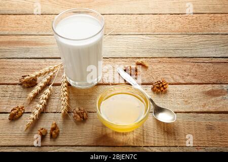 Composizione con il latte e il miele su sfondo di legno Foto Stock