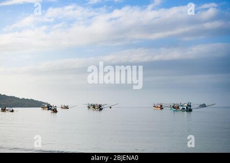 Vista del cielo blu e della superficie d'acqua calma con i pescherecci galleggianti a coda lunga per la pesca vicino all'isola di Pollo di Poda in Thailandia Foto Stock