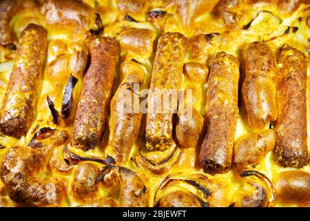 Toad vegetariano cotto in casa nel buco. Il piatto è preparato con salsicce vegetariane e pastella. Foto Stock