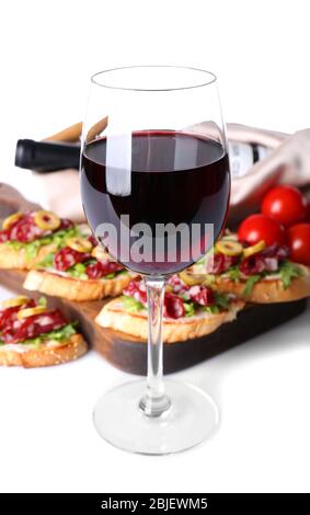 Bicchiere di vino e gustose bruschettas sullo sfondo Foto Stock