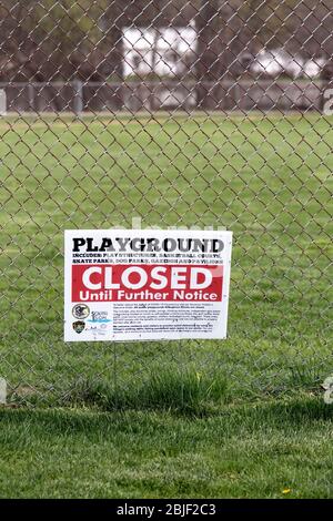 South Elgin, Illinois, Stati Uniti. Un parco vuoto circonda un cartello che dichiara i componenti selezionati dell'area da chiudere. Foto Stock