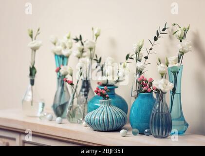 Bella composizione con fiori freschi in vasi su mantelepiece Foto Stock