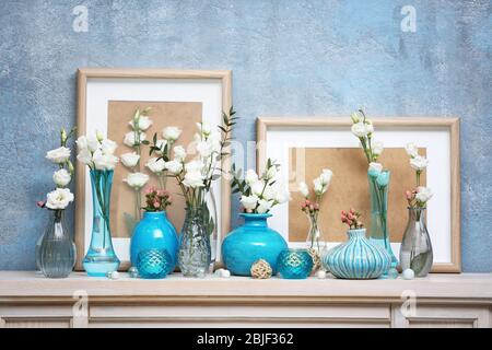 Bella composizione con fiori freschi su mantelpiece Foto Stock