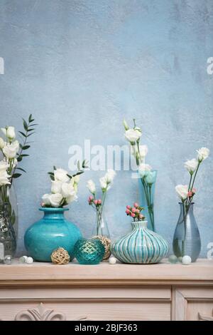 Bella composizione con fiori freschi su mantelpiece Foto Stock