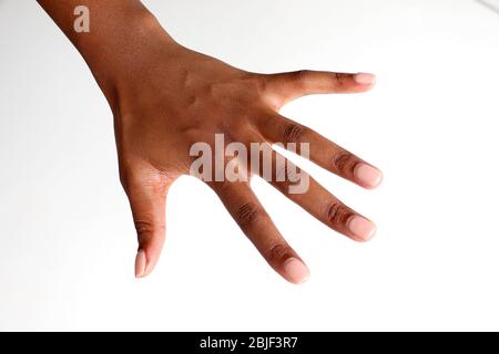 Mano femminile isolata nera africana indiana rivolta verso il basso mostrando chiodi curati Foto Stock