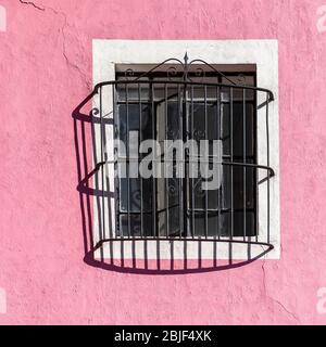 Facciata rosa con finestra e decorazione in ferro battuto a Puebla, Messico. Foto Stock