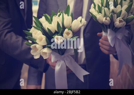 Sposo e sposatore con bouquet belli Foto Stock