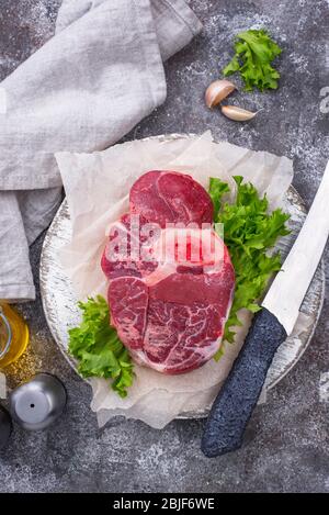 Bistecca di manzo cruda ossobuco sul tagliere Foto Stock