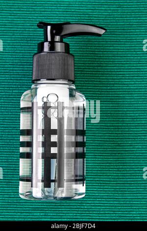 Antisettico o igienizzante per mani contenente alcol, in flacone di plastica con dispenser, fondo verde. Un disinfettante di nuovo per la protezione Foto Stock