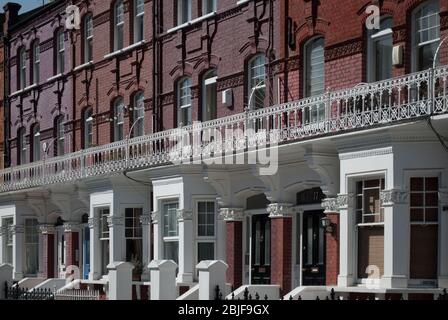 Colorato vittoriano terrazzato alloggi Row Houses Red Brick classica tradizionale Street Pattern su Avenmore Road, West Kensington, Londra W14 Foto Stock