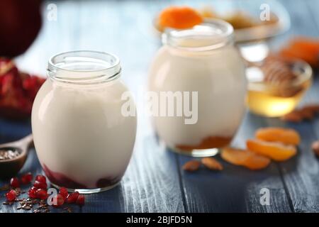 Bicchieri con delizioso yogurt su tavolo di legno Foto Stock