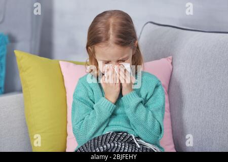 Piccola ragazza malata con tovagliolo a casa Foto Stock