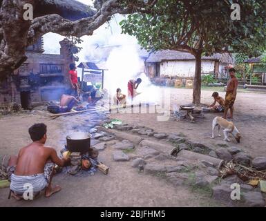 Uomini che cucinano cibo a fuoco aperto nel centro del villaggio, Tenganan Antico Villaggio, Tenganan, Bali, Repubblica di Indonesia Foto Stock