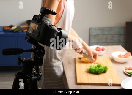Giovane donna che si prepara per il cibo di ripresa in studio fotografico Foto Stock