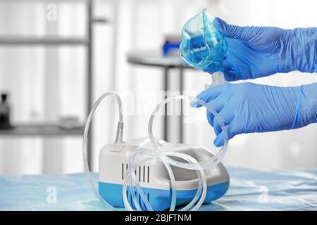 Medico che prepara il nebulizzatore a compressore per l'uso Foto Stock