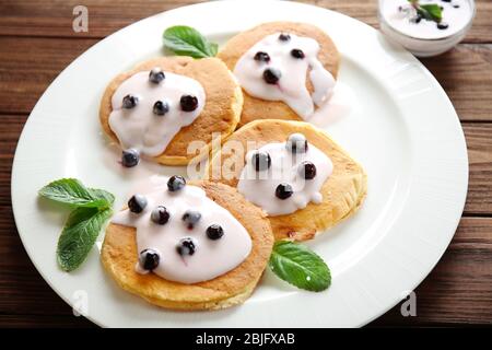 Deliziosi pancake con frutti di bosco e yogurt a piatto Foto Stock