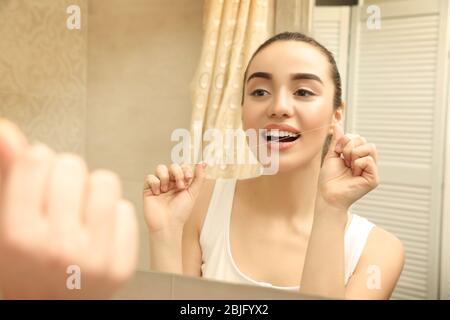 Bella donna che sfrega i denti in bagno Foto Stock