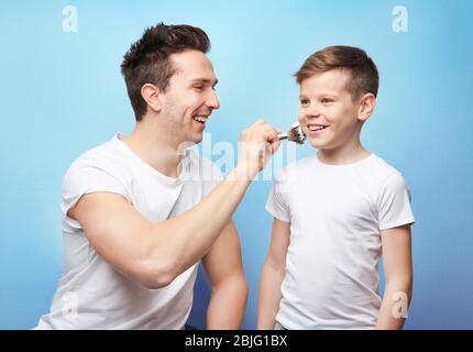 Padre e figlio rasano su sfondo chiaro Foto Stock