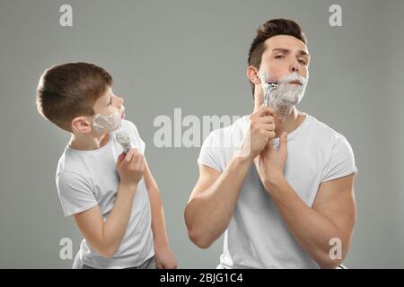 Padre e figlio rasano su sfondo chiaro Foto Stock