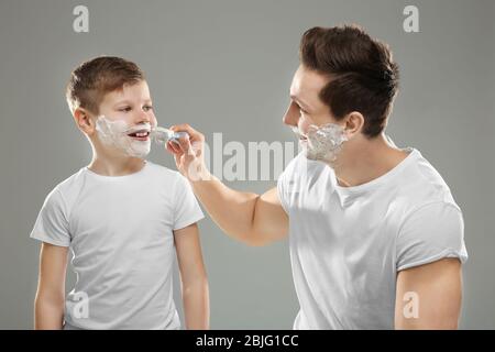 Padre e figlio rasano su sfondo chiaro Foto Stock