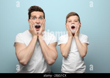 Padre e figlio rasano su sfondo chiaro Foto Stock